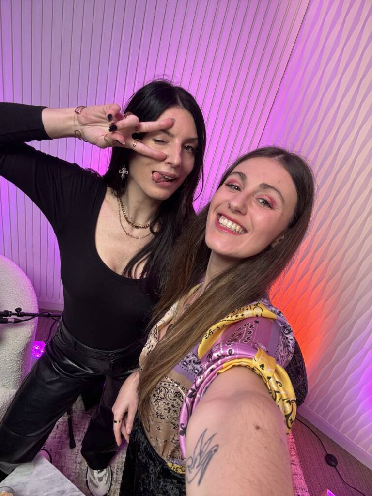 Chloé et Anouck du podcast Féminitea en studio, souriantes et complices devant un décor rose et violet